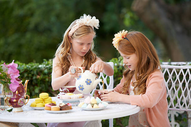 Two young girls having a tea party in the backyard